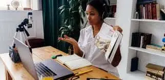 this is the image of a women who is selling courses online in his laptop while attending a meeting. selling courses online with his speaking skills .this can be done after writing a ebook. 